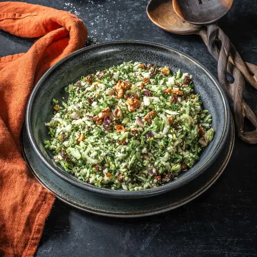 Broccoli and cauliflower rice salad with red onion, raisins and walnuts